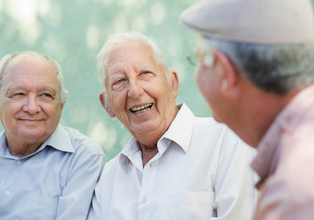 senior men enjoying a laugh together on the park bench