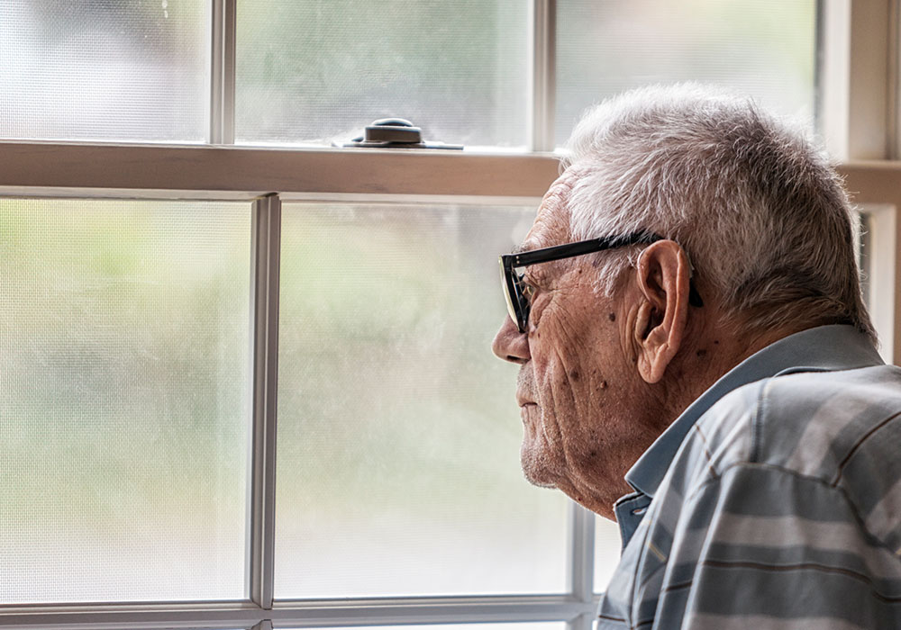 Older gentleman looking out of window