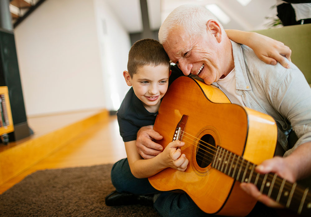 Young Boy Playing Guitar with Grandfather